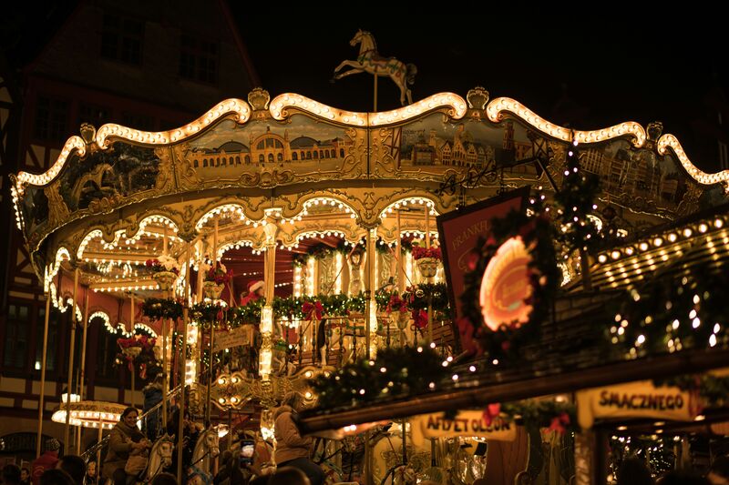 a beautiful historic carousel at the Frankfurt Christmas Market in Germany. The amazing medieval truss houses create an unfathomable beautiful “winter wonderland” atmosphere.